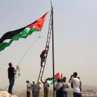 فلسطينيون يرفعون العلم الفلسطيني خلال تظاهرة ضد الاستيطان في قرية النبي صالح