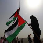 فلسطينيون يرفعون العلم الفلسطيني خلال تظاهرة ضد الاستيطان في قرية النبي صالح