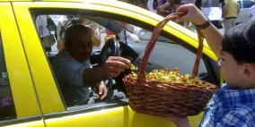 أطفال الأسرى المضربين عن الطعام يوزعون الحلوى على المواطنين في الخليل