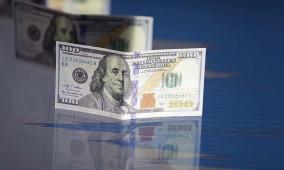 الدولار يتراجع مع توتر الأسواق وتقلص التوقعات برفع الفائدة